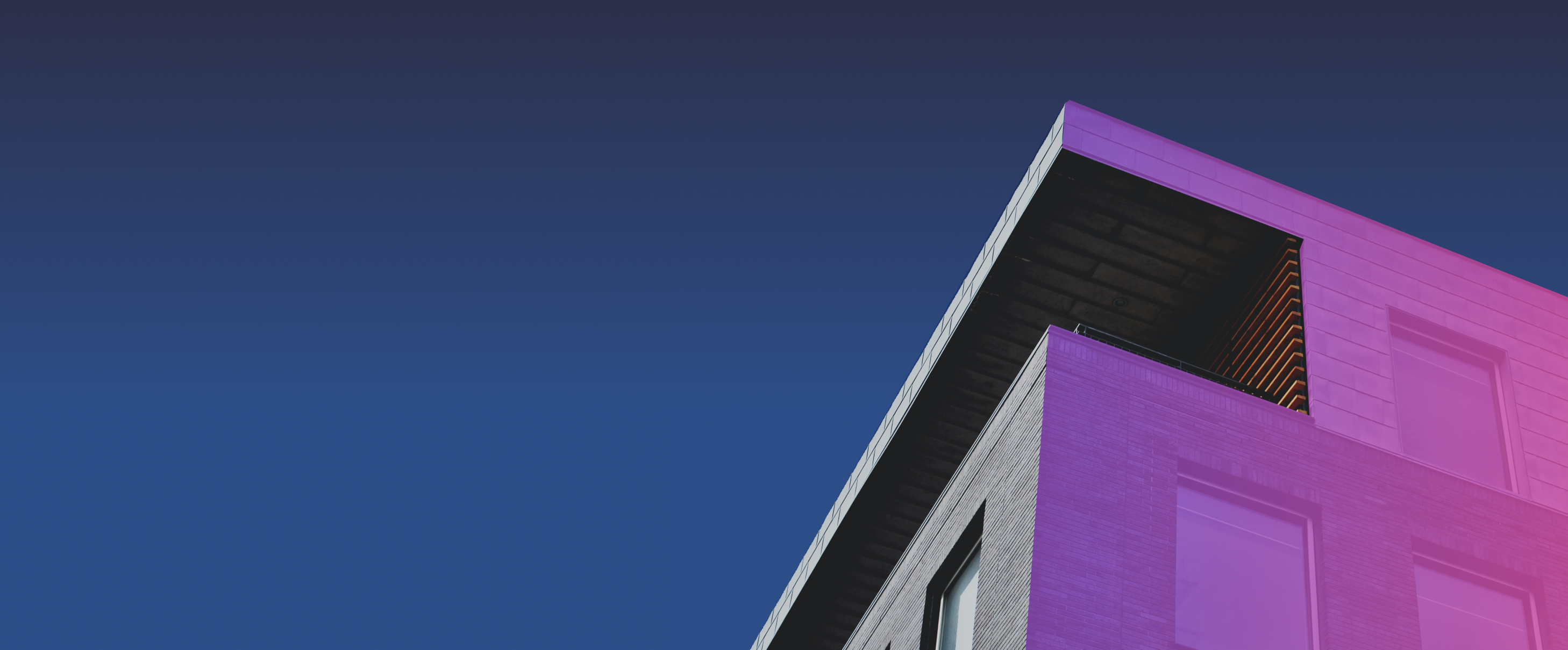 Appartment building against dark sky with one side colored in a purple and pink gradient
