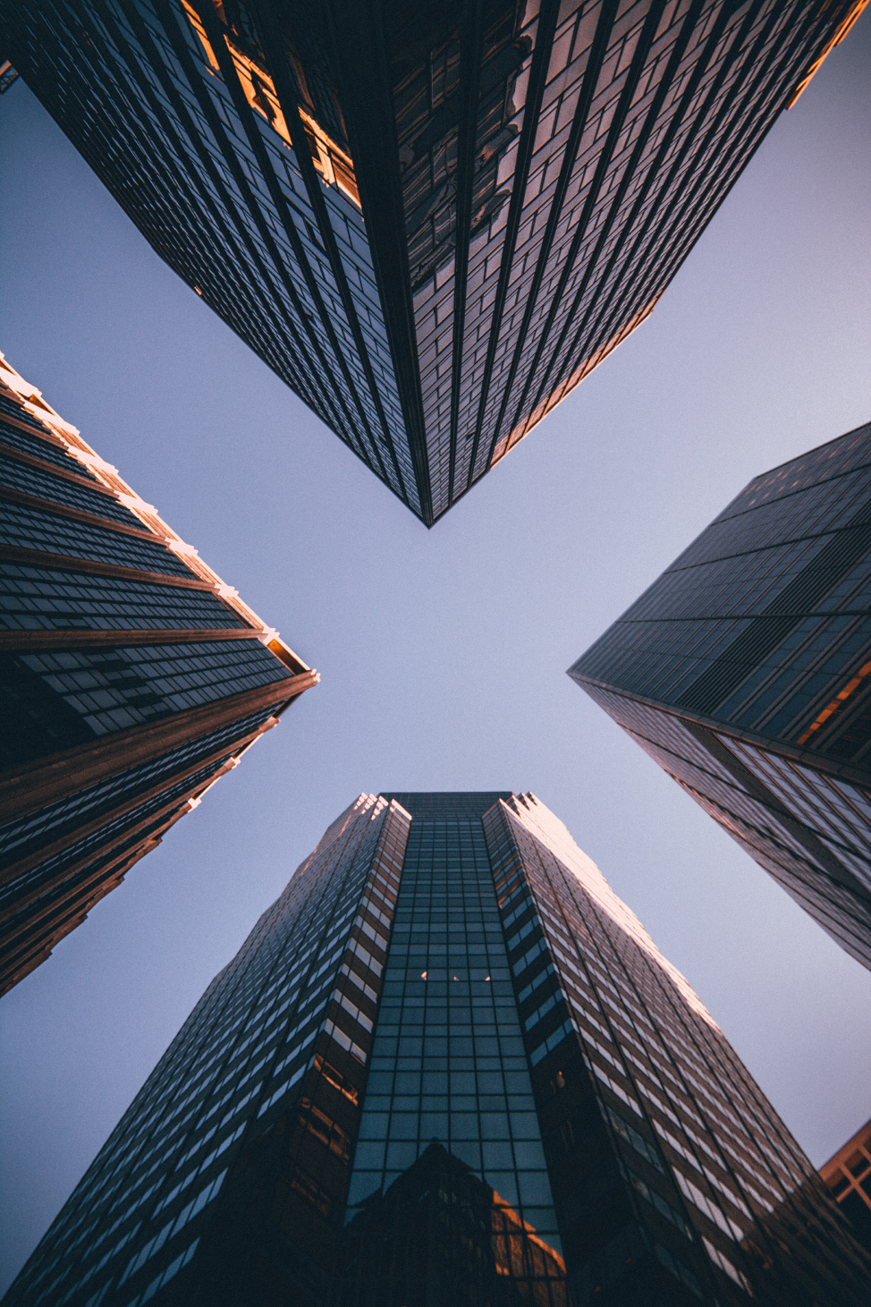 Looking up at the sky, with 4 skyscrapers on each side of the image